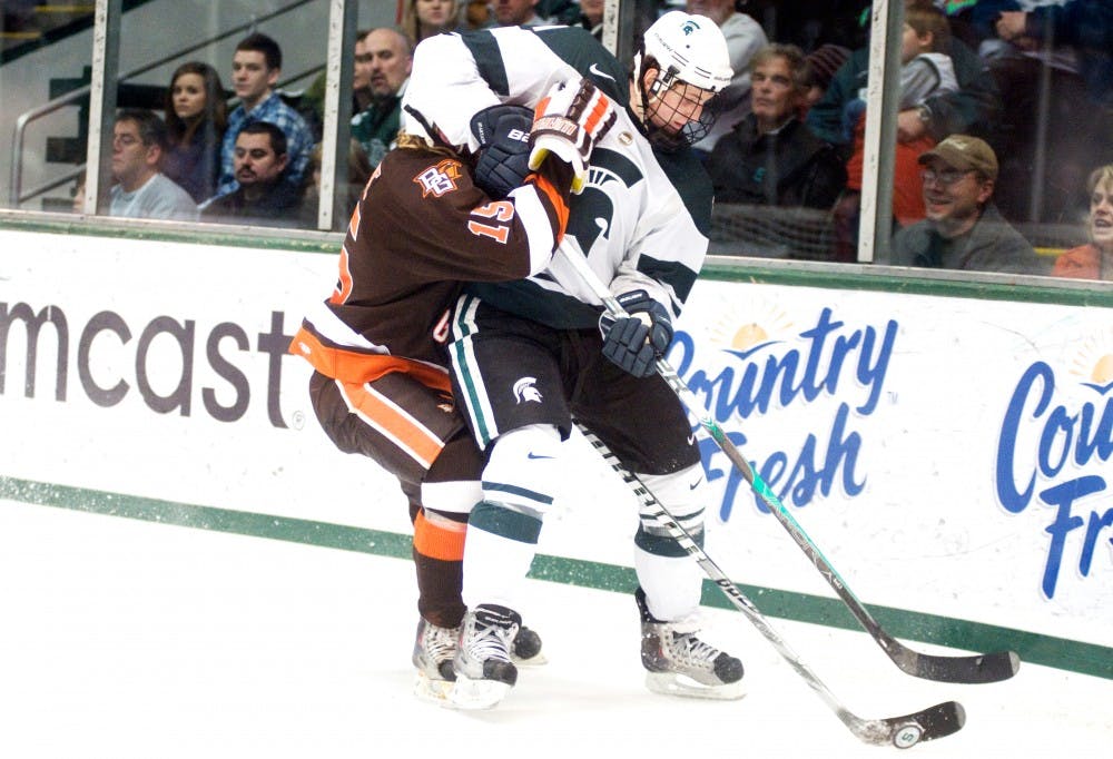 	<p>Junior center Brett Perlini takes on Bowling Green defensemen Andrew Krelove at the hockey game Saturday night. The Spartans defeated the Falcons, 2-0, in the last home game of the season. H?l?ne Dryden/The State News</p>