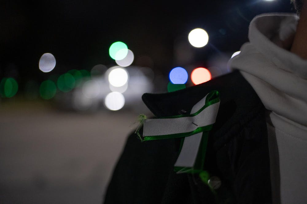 <p>Finn Gomez, a journalism junior at Michigan State University, wore a green and white ribbon at the remembrance ceremony on Feb. 13, 2024. Gomez received the ribbon at the vigil held last February after the campus shooting.</p>