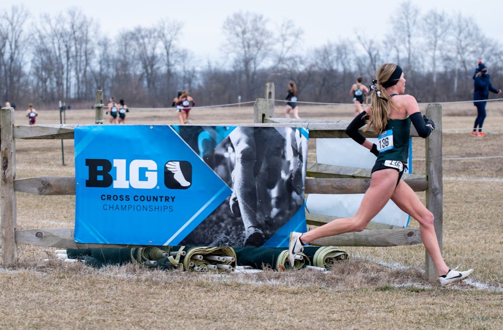 <p>A Michigan State runner passes the Cross Country Big Ten Championship sign, as they were on their way to a second consecutive Spartan title on Jan. 30, 2021.</p>