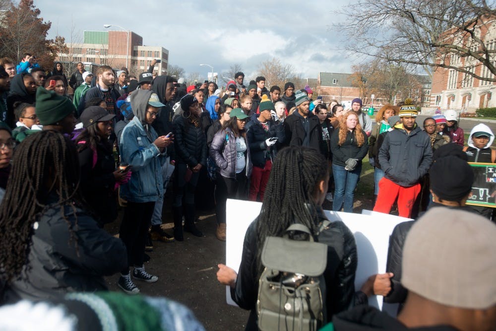 <p>Students gather around the rock after a march on Nov. 13, 2015, at the rock on Farm Lane. A police escort followed the march, where students held signs and yelled chants in solidarity with the students at the University of Missouri. </p>
