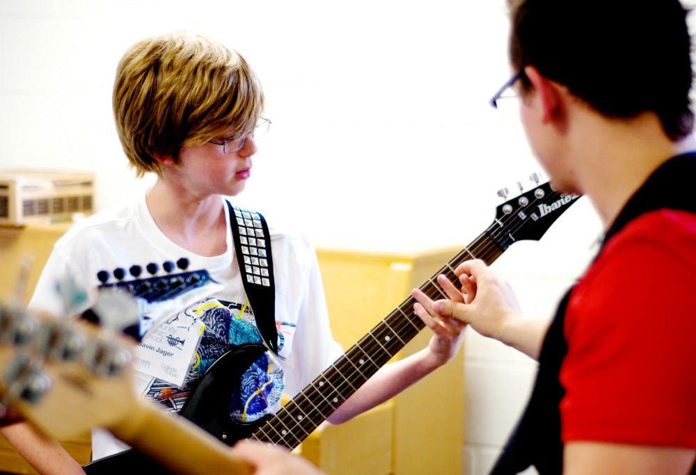 	<p>Andrew Dornoff of The Outer Vibe instructs Rock Camp student Gavin Jager, 14, on guitar Monday at the <span class="caps">MSU</span> Community Music School located at 841 Timberlane Street in East Lansing.  Jager and his peers rehearse Revolution, a song by The Beatles, for their Friday performance at the Common Ground Music Festival in Lansing.  Mackenzie Mohr/The State News</p>