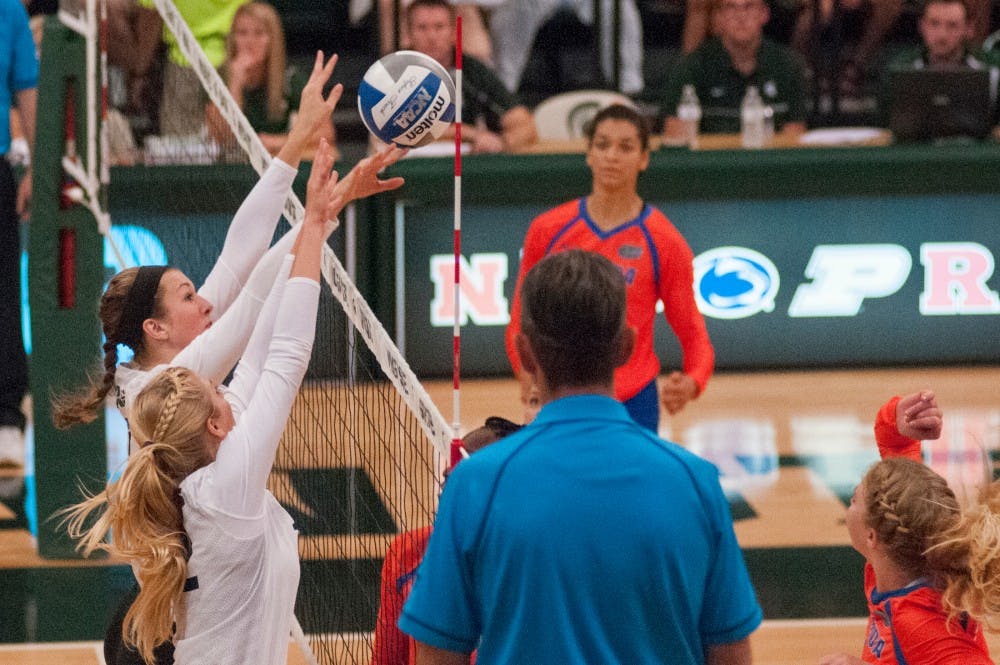 Junior middle blocker Alyssa Garvelink (17) and junior setter Rachel Minarick (12) block the volleyball from going over the net during the volleyball game against the University of Florida on Sept. 4, 2016 at Jenison Field House. The Spartans were defeated by the Gators, 3-0.