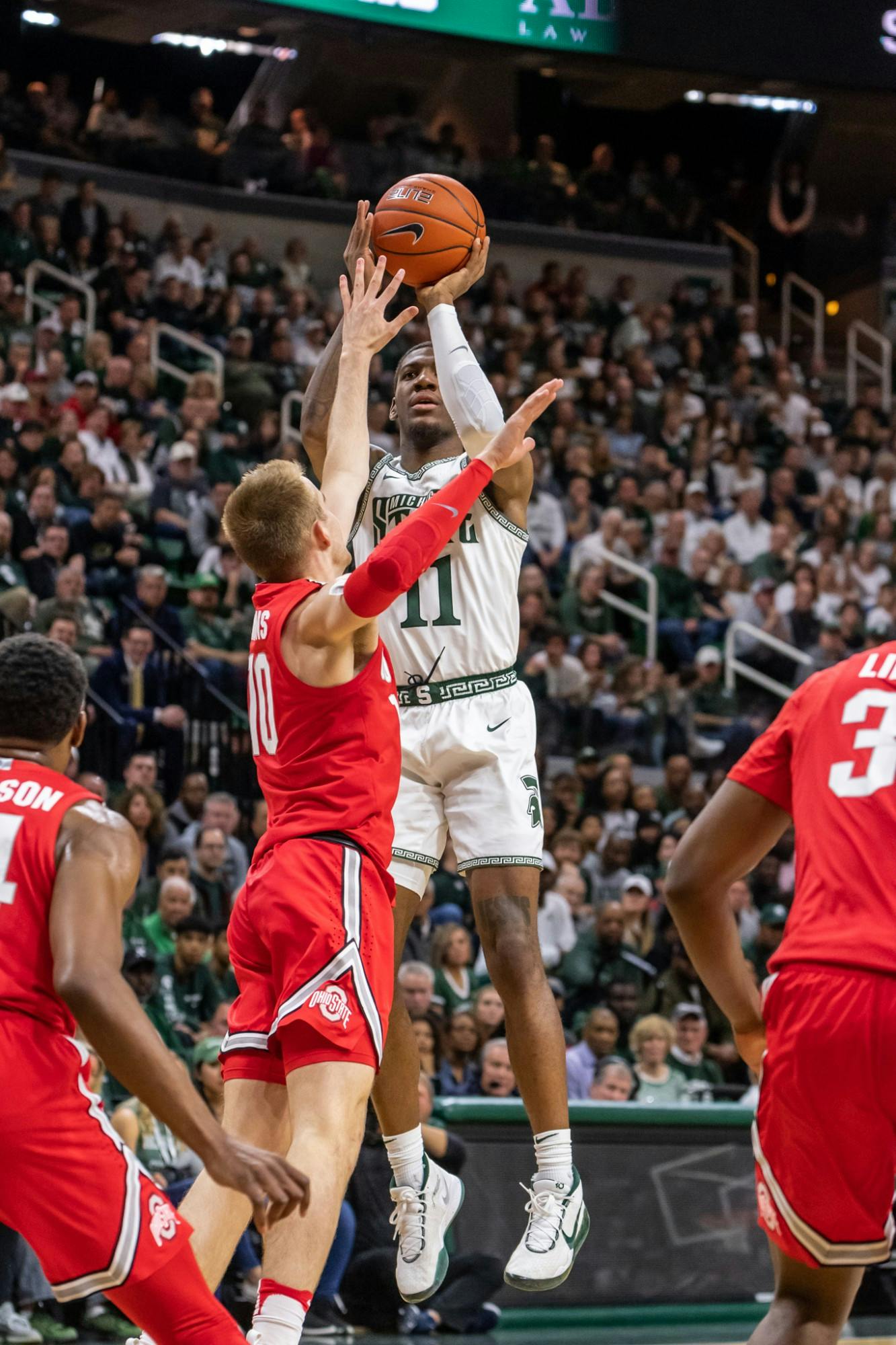 Sophomore forward Aaron Henry (11) shoots over Ohio State’s Justin Ahrens (10). The Spartans defeated the Buckeyes, 80-69, at the Breslin Student Events Center on March 8, 2020. 