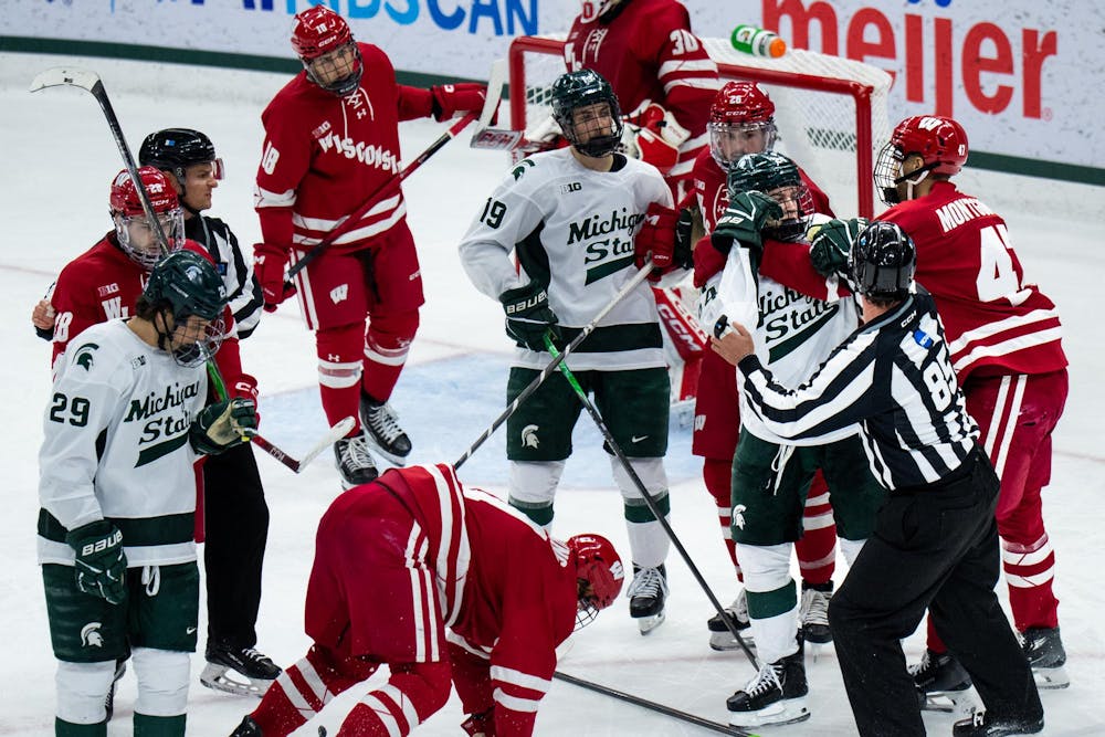 <p>Michigan State forward Nathan Mackie (24) fights Wisconsin forward Blake Montgomery (7) during a game at Munn Ice Arena in East Lansing, Mich., on Saturday, Nov. 22, 2025.</p>