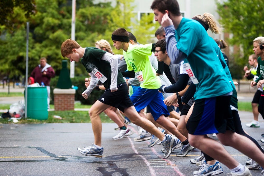 Runners take off at the start in front of the Auditorium for the Residence Halls Association Spartan Sprint 5K race on Sunday morning through campus. Proceeds from the race benefit Ele's Place, a local center for grieving children. Lauren Wood/The State News