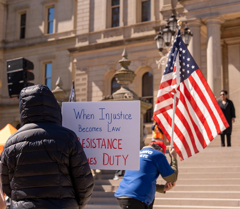 <p>A protestor holds a sign at the No Kings Protest held at the Michigan State Capitol in Lansing, MI on March 28, 2026.</p>
