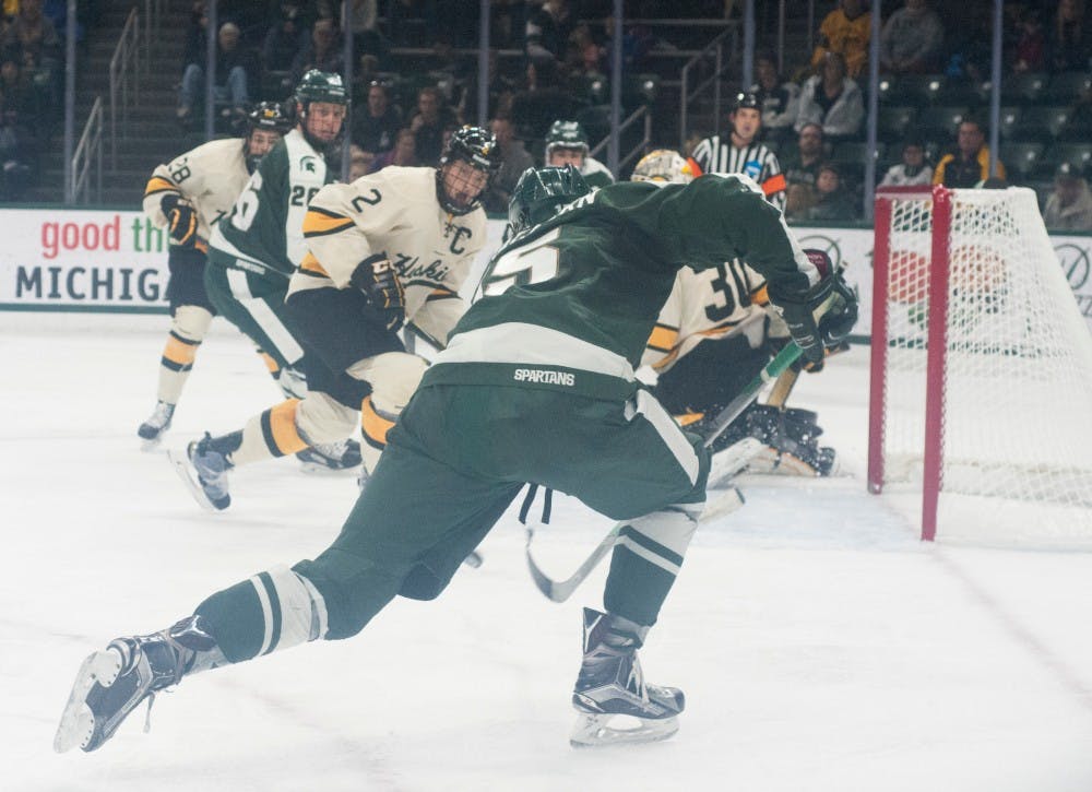 Junior forward Mackenzie MacEachern, 15, scores a goal during the second period of the game against Michigan Tech on Nov. 22, 2015 at Munn Ice Arena. The spartans tied with the Huskies, 4-4.