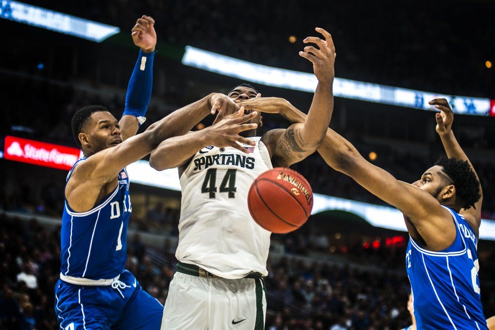 <p>Duke guard Trevor Duval (1), center Marques Bolden (20), knock the ball out of sophomore forward Nick Ward's (44) hands during the Champions Classic during the game against Duke on Nov. 14, 2017 at the United Center. The Spartans were defeated by the Blue Devils, 88-81.&nbsp;</p>