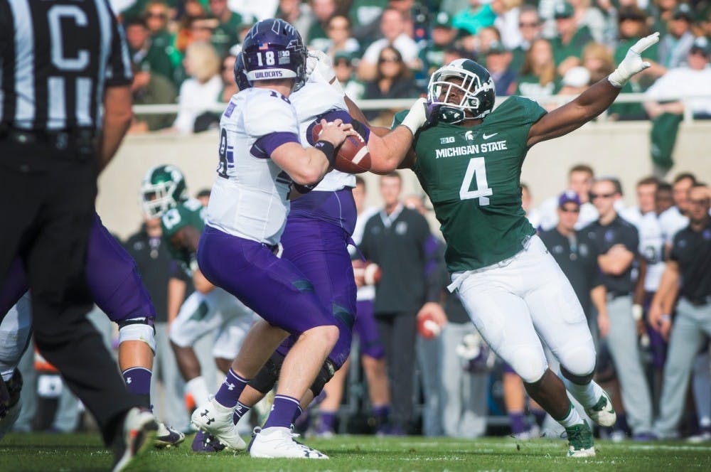 Junior defensive lineman Malik McDowell (4) puts pressure on Northwestern quarterback Clayton Thorson (18) as he attempts to throw a pass during the first quarter of the game against Northwestern on Oct. 15, 2016 at Spartan Stadium. The Spartans were defeated by the Wildcats, 54-40.