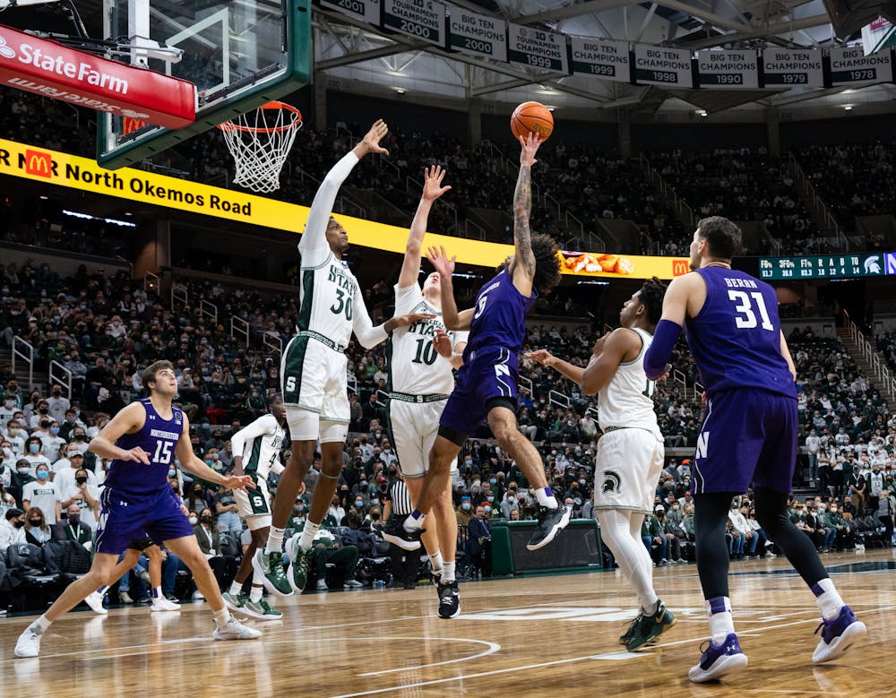 <p>Northwestern&#x27;s junior guard Boo Buie (0) attempts to shoot the ball while being guarded by Michigan State&#x27;s senior center Marcus Bingham Jr. (30) and redshirt senior forward Joey Hauser (10) during Michigan State&#x27;s loss on Jan. 15, 2022.</p>