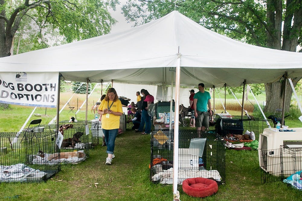 	<p>Volunteers and potential new dog owners browse the dog adoption tent of the Ingham County Animal Control and Shelter, June 7, 2013, in a field near the shelter in Lansing during the 30-hour 2013 Adopt-A-Fest. Volunteers from the shelter were out Friday and Saturday to adopt out as many animals as they could. Danyelle Morrow/The State News</p>