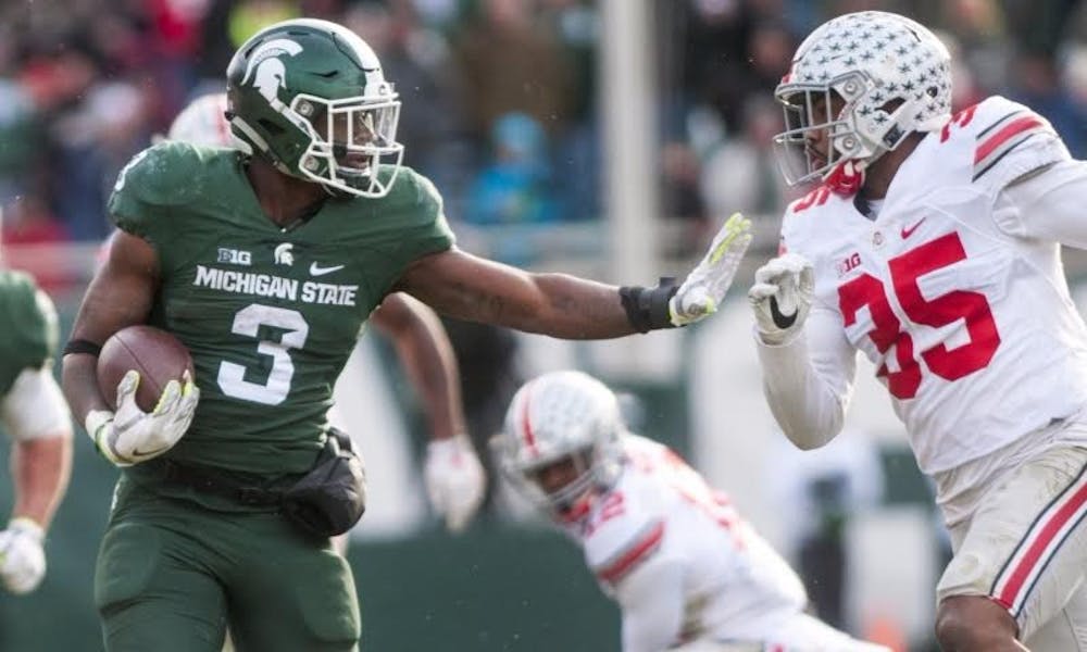<p>Sophomore running back LJ Scott (3) holds his arm out to fend off Ohio State linebacker Chris Worley (35) during the game against Ohio State on Nov. 19, 2016 at Spartan Stadium. The Spartans were defeated by the Buckeyes, 17-16.<br>
</p>