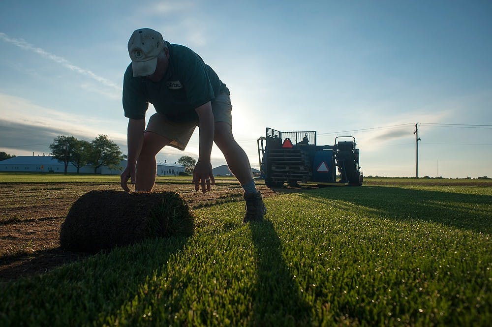 	<p>Farm manager Mark Collins picks up the turf June 18, 2013, near the Hancock Turfgrass Research Center, 4444 Farm Lane. The center supplies turfgrass to athletic fields on campus, as well as supporting the turfgrass research of the Department of Crop and Soil Sciences. Justin Wan/The State News</p>