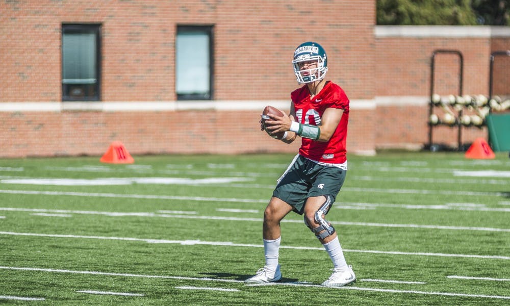 <p>Red shirt sophomore Messiah deWeaver (10) looks to throw the ball while performing a drill during the football practice on July 31, 2017, at the practice fields behind the Duffy Daugherty Football Building</p>