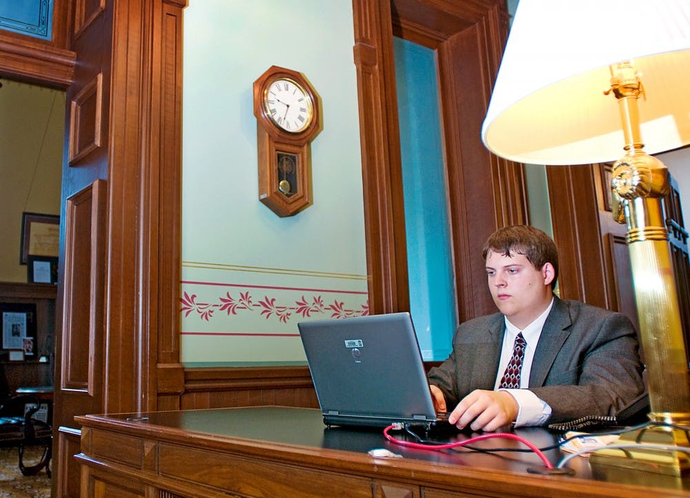 	<p><span class="caps">MSU</span> senior Andrew Martini answers emails and occasional phone calls while interning with House Minority Leader Richard Hammel inside the Capitol Building Tuesday morning. Martini noted that the most difficult part of his job is attempting to aid constituents and their personal battles with corporate agencies.</p>