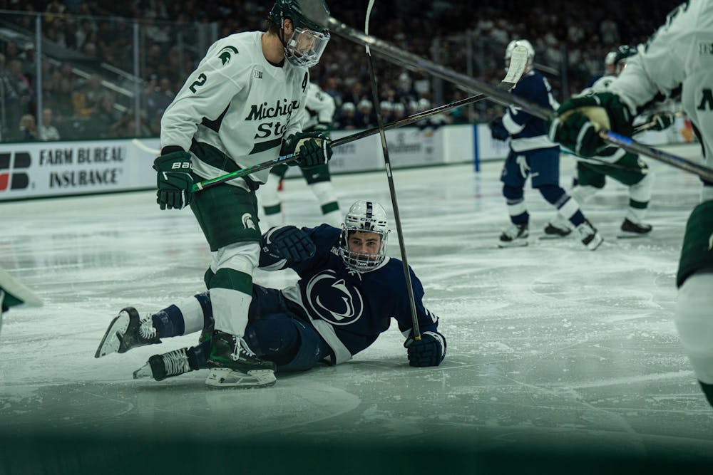 MSU junior defender, Patrick Geary (2) stands over Penn State junior forward, Reese Laubach (29) after being slammed to the ground during the MSU versus Penn State Men's Hockey game at Michigan State University's Munn Ice Arena on Friday, Nov. 7, 2025