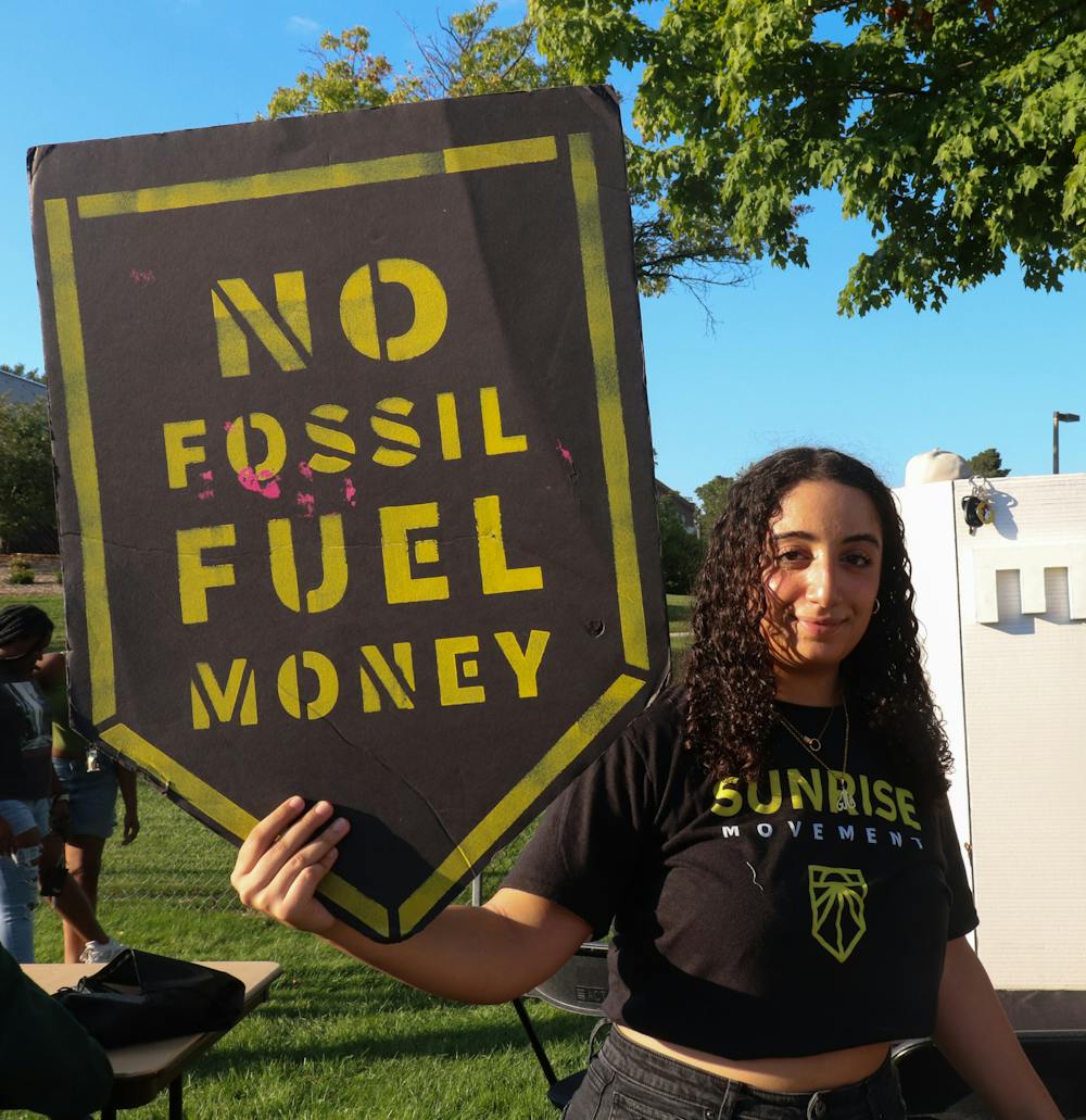 <p>Social relations junior Vallen Krikor poses at the Sunrise Movement Organization booth at Spartan Remix on Sept. 8, 2022. Sunrise movement is an organization that focuses on tackling issues of climate change and divesting from fossil fuels. </p>