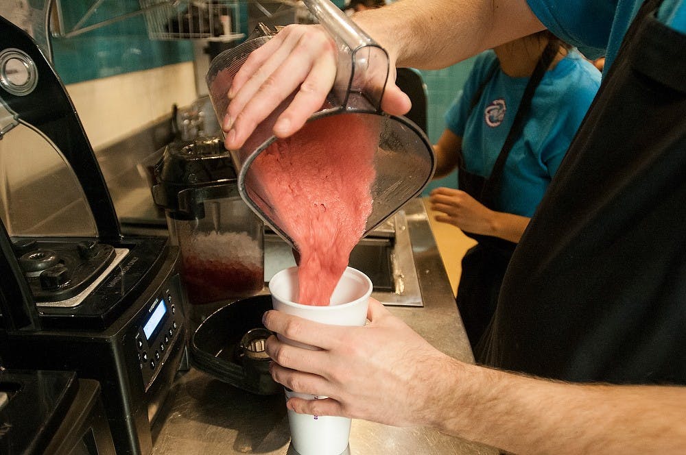 <p>Kinesiology junior Jason Johnson pours a blended smoothie into a cup Dec. 3, 2014, at Tropical Smoothie, 1201 E. Grand River Ave in East Lansing. Tropical Smoothing hosted a fundraiser at the store for the Honors College at MSU. Dylan Vowell/The State News</p>