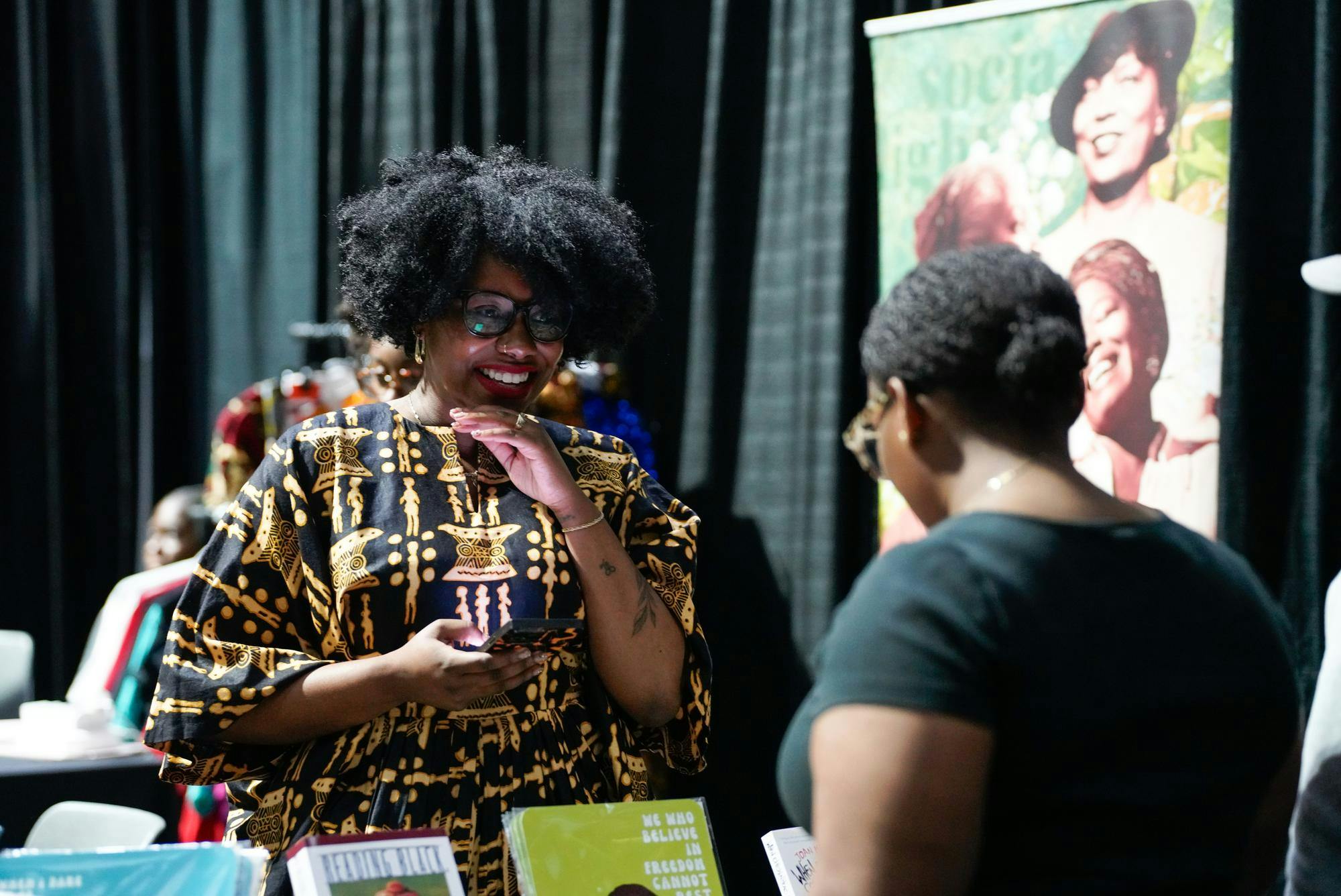 <p>Socialight Society founder Nyshell Lawrence speaks to an attendee at the Black Wall Street vendor fair on June 14, 2024. </p>