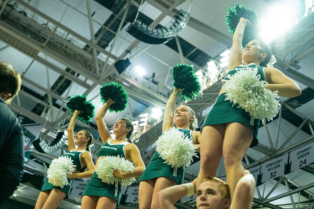 <p>MSU cheerleaders stand a cheer under the spotlight before the MSU versus Toledo men's basketball game at the Breslin Center in East Lansing, Michigan on Tuesday, Dec. 16, 2025.</p>