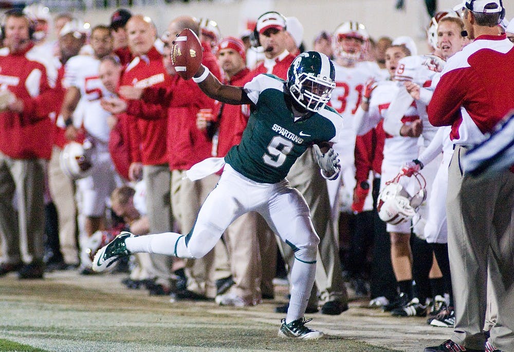 	<p>Sophomore safety Isaiah Lewis holds out an intercepted ball as he steps out of bounds Saturday at Spartan Stadium. The Spartans defeated the Wisconsin Badgers 37-31. Matt Radick/The State News</p>