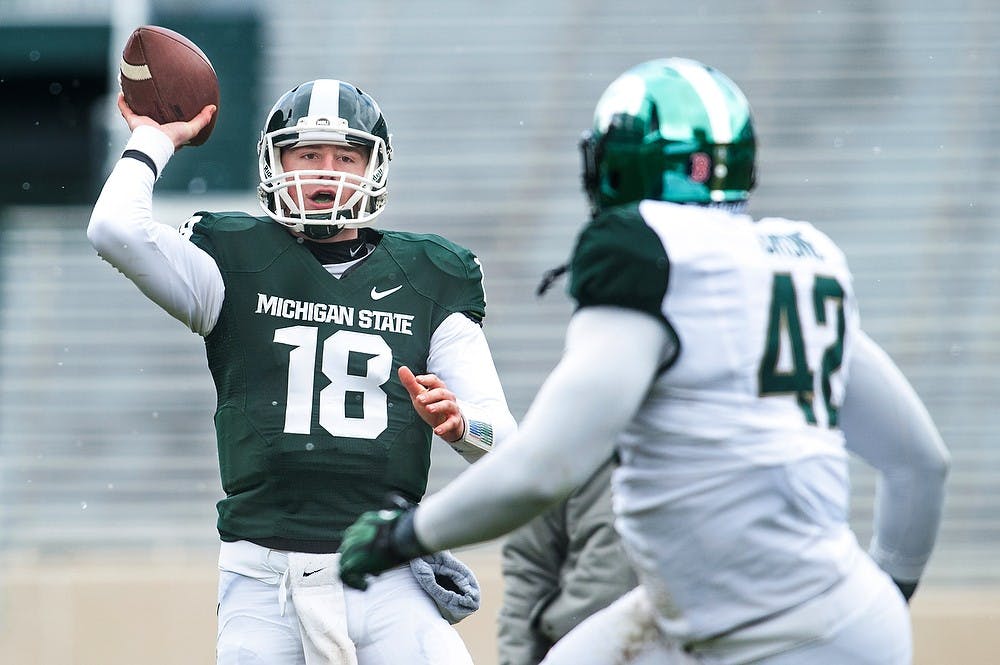 	<p>Sophomore quarterback Connor Cook attempts a pass as senior defensive end Denzel Drone plays defense, April 20, 2013, at Spartan Stadium. The White team defeated the Green team, 24-17, during the annual Green and White Spring Game. Justin Wan/The State News</p>