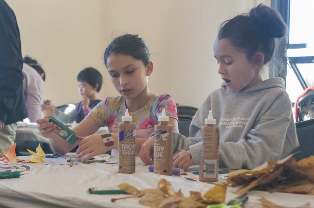 From left, East Lansing residents Regan Delrio (8) and Tauren Delrio (10) make puppets on Nov. 13, 2016 in the Union. Interdisciplinary studies senior CJ, who is the multicultural director for UAB, said the activity was meant to be fun and teach kids about the history of puppetry.