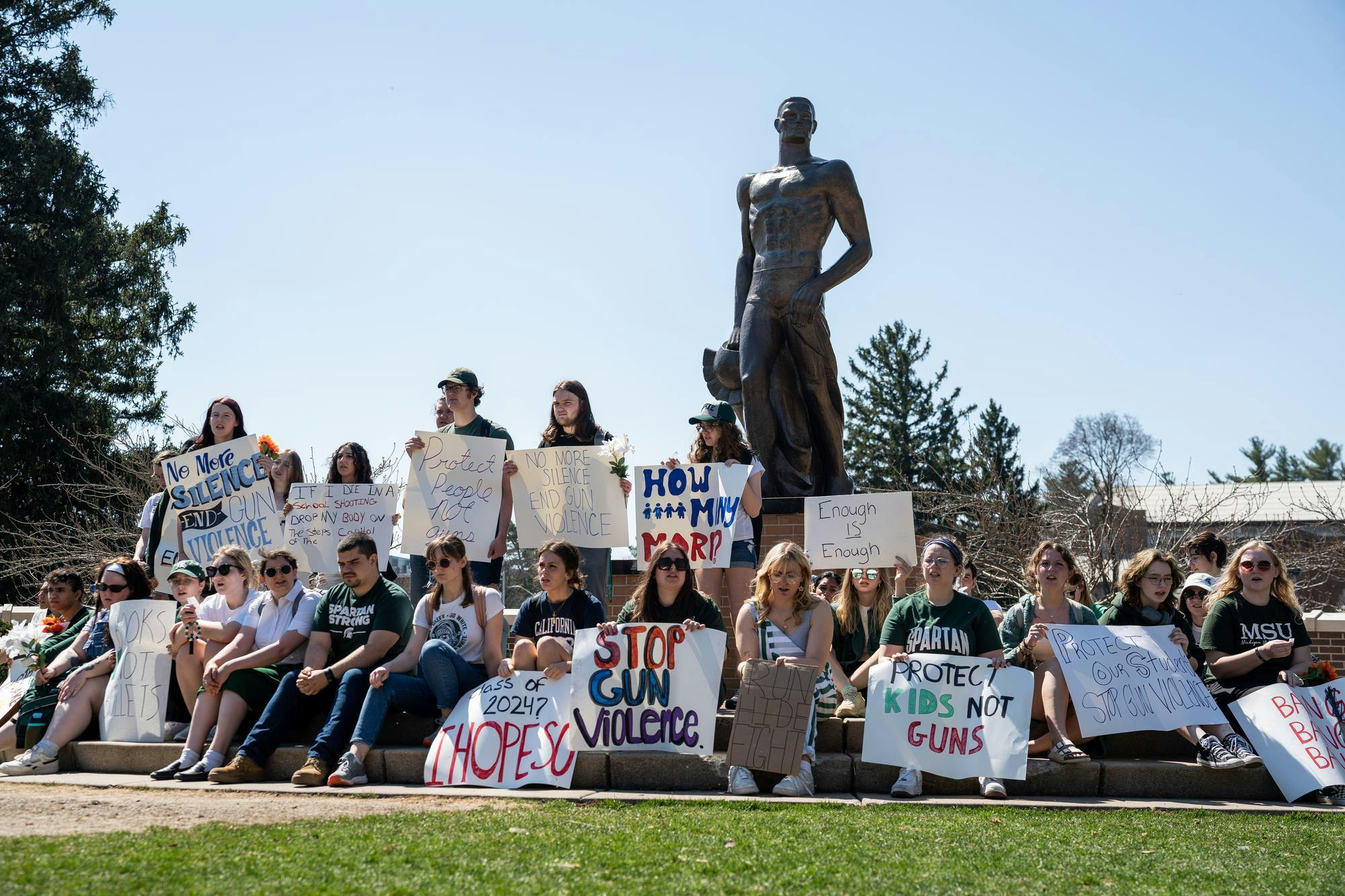 <p>MSU students sit at the Spartan Statue after their walkout protest against gun violence on April 12, 2023.</p>