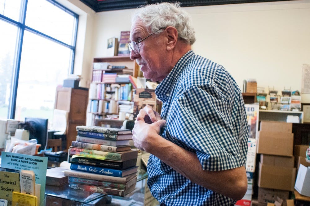 <p>Lansing resident Ray Walsh talks to a customer on April 19, 2017 at Archives Book Shop at 519 W Grand River Ave. Walsh's shop will participate in the 65th Michigan Antiquarian Book and Paper Show, featuring rare and collectible items, on April 23, 2017.&nbsp;</p>