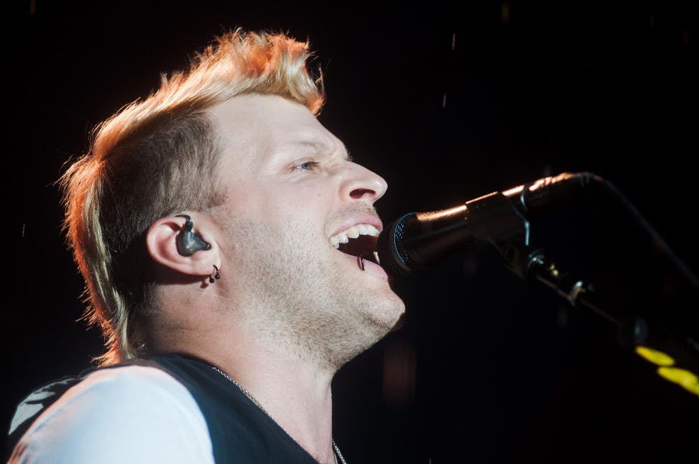 Three Days Grace bassist Brad Walst sings during their performance at Common Ground in Lansing’s Adado Riverfront Park on Saturday, July 14, 2012. Rain slightly delayed their performance. Julia Nagy/The State News