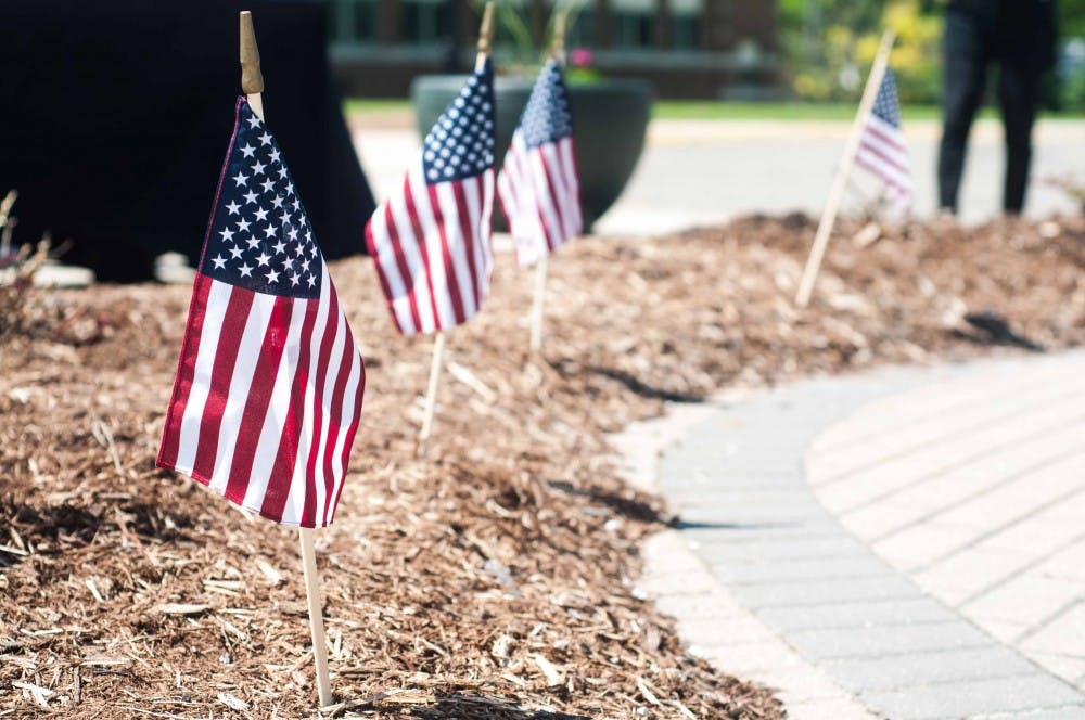 Flags flutter in the wind after the Medal of Honor Memorial wreath laying at the Hannah Community Center on May 24, 2018. (Annie Barker | State News)