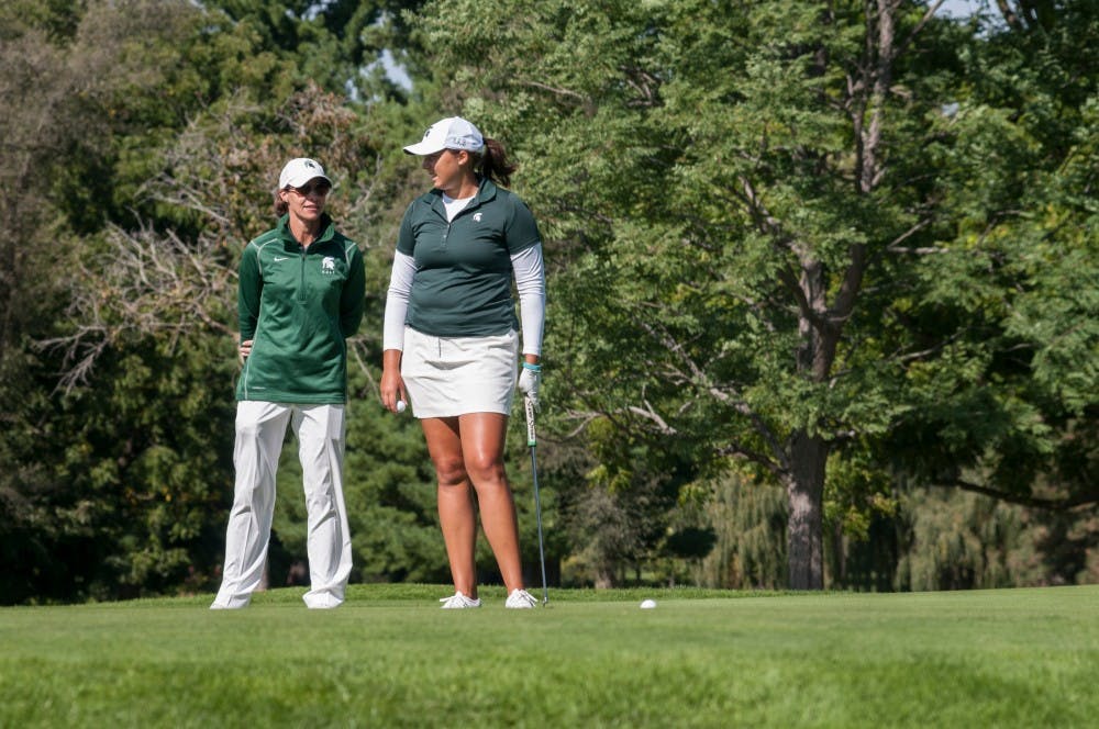 Women's golf head coach Stacy Slobodnik, left, talks with redshirt-junior Katie Sharp before a putt on Sept. 25, 2016 at Forest Akers West Golf Course. Slobodnik has held the head coaching position at MSU for 19 years. 