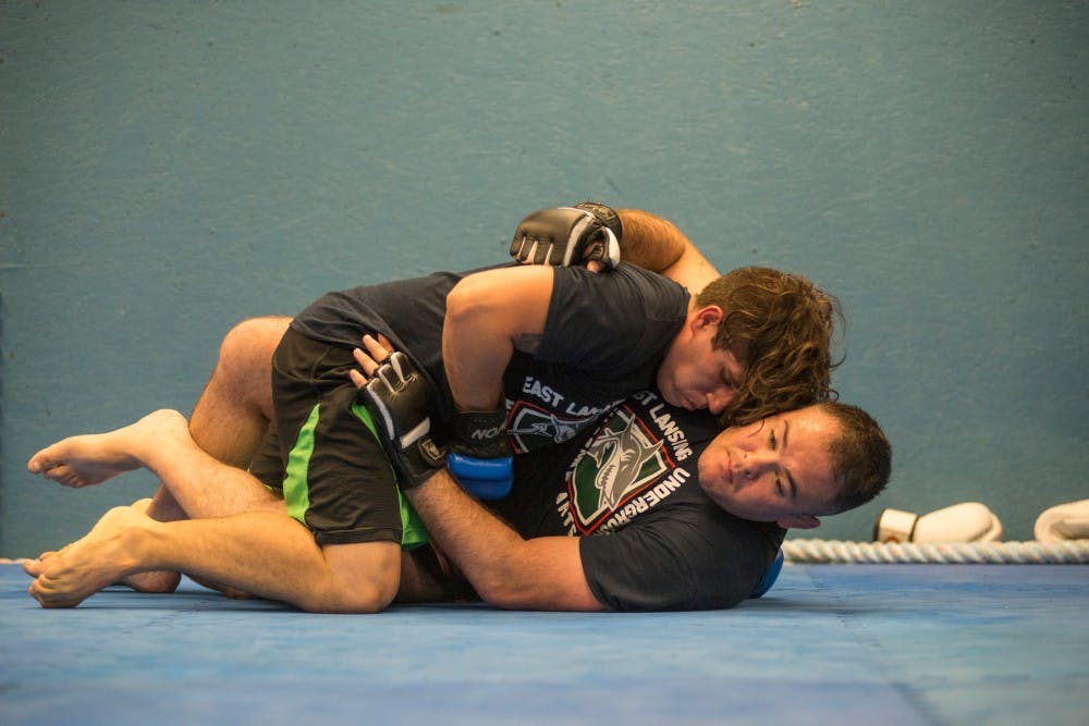 East Lansing resident Matt Torres, bottom, and Haslett, Mich. resident Jordan Rivas grapple one another on Aug. 2, 2016 at East Lansing Underground Martial Arts at 541 E. Grand River Ave.