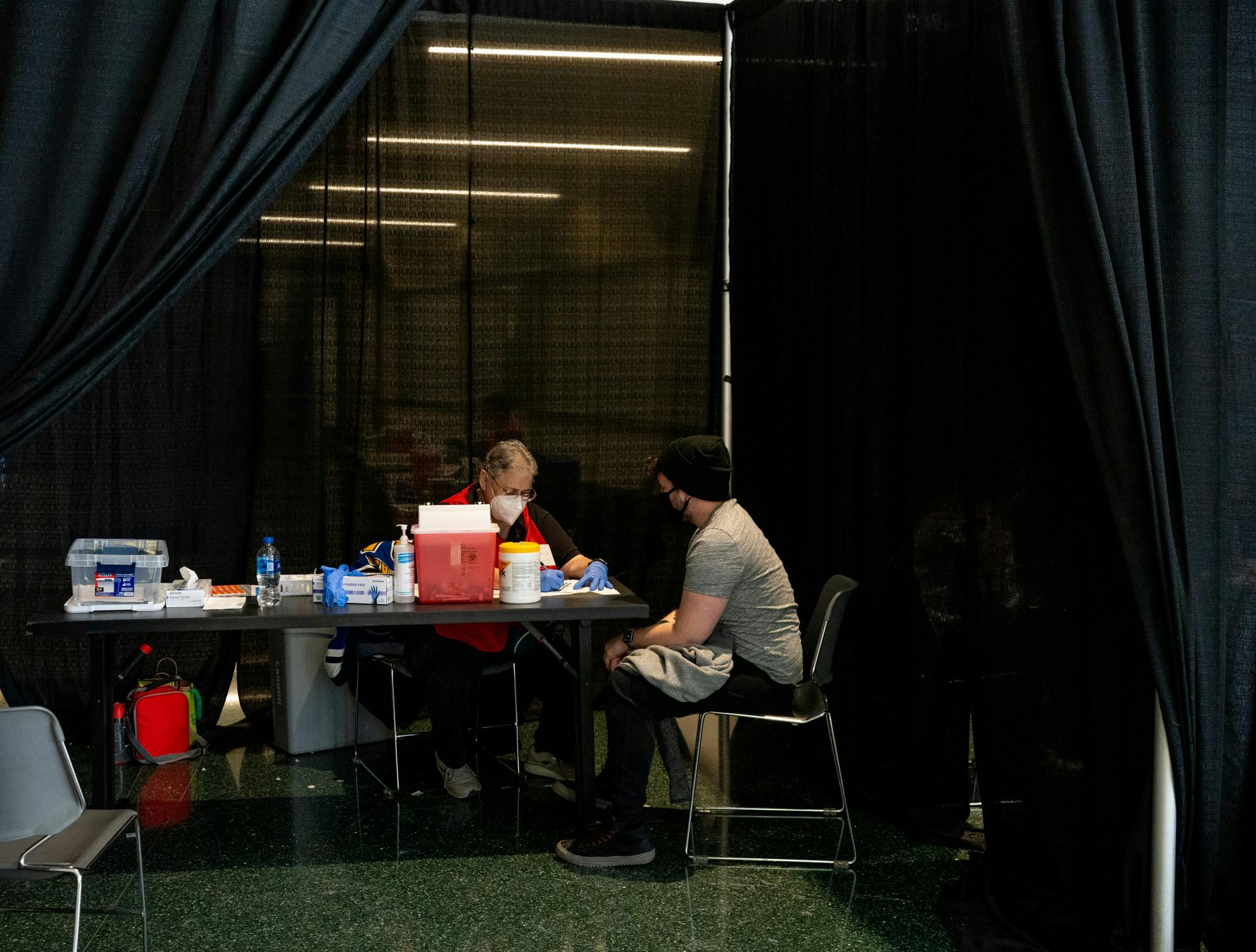 <p>Volunteer and retired paramedic Esther Perez runs down a list of information and guidelines with MSU researcher Hunter Pierson before he gets the COVID-19 vaccine on Jan. 22, 2022. </p><p>“I think the most important thing is if we don&#x27;t volunteer and get these done, we won&#x27;t protect the country, so I try to volunteer for every one of these I can. The more people we have, the more shots in arms, the sooner we get away from this virus and back to safety,” Perez said.</p>