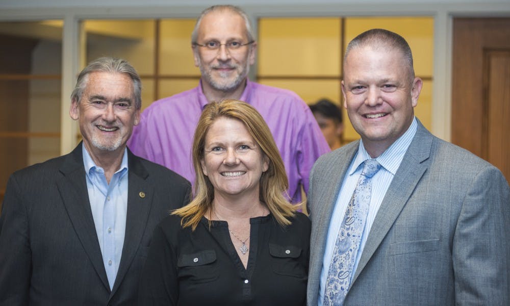 <p>From left to right, East Lansing Mayor Mark Meadows, East Lansing City Council Member Shanna Draheim (front), East Lansing City Council Member Erik Altmann (back) and East Lansing's Chief of Police Jeff Murphy pose for a photo during Murphy's retirement ceremony on May 30, 2017 at East Lansing Hannah Community Center at 819 Abbot Rd. Murphy was honored for his 30 years of service with the East Lansing police department.</p>