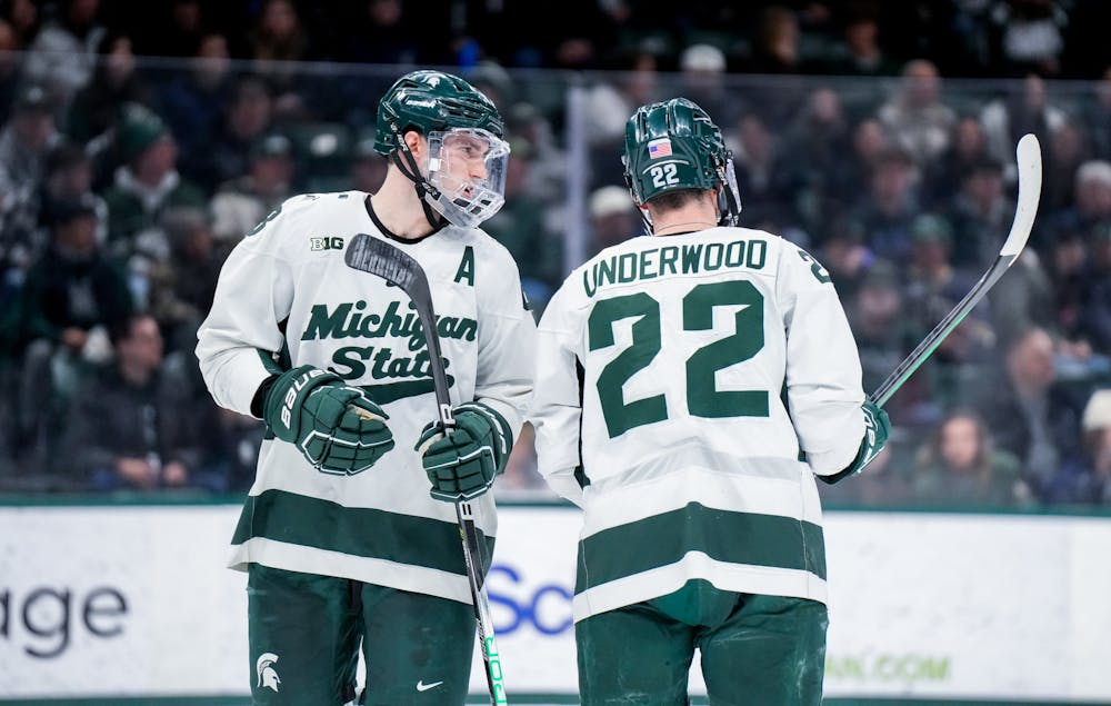 <p>Fifth-year defender Cole Krygier (8) exchanges words with fellow teammate graduate student defender Michael Underwood (22) during a game against Notre Dame at Munn Ice Arena on Feb. 3, 2023. The Spartans defeated the Fighting Irish 3-0.</p>