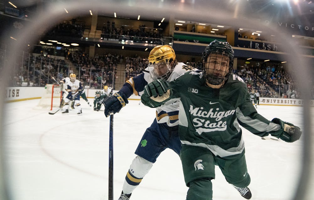 <p>Notre Dame sophomore forward Tyler Carpenter muscles Spartan junior forward Jeremy Davidson into the boards at Compton Family Ice Arena in Notre Dame, IN on Friday, March 3, 2023. The low-scoring game ended in a 1-0 victory for Notre Dame.</p>
