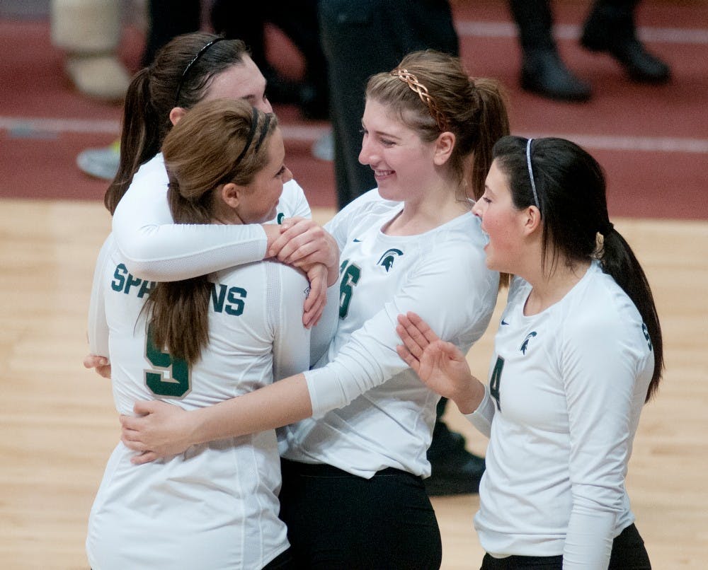 Sophomore outside hitter Taylor Galloway,9, and freshman middle blocker and outside hitter Maggie Halloran, 16, hug junior outside hitter Lauren Wicinski, 15, while celebrating with freshman setter Halle Peterson, 4, after the MSU volleyball team beat Iowa 3-0 on Nov. 2, 2012, at Jenison Field House. MSU is due to play Nebraska on Nov. 3, 2012. Danyelle Morrow/The State News