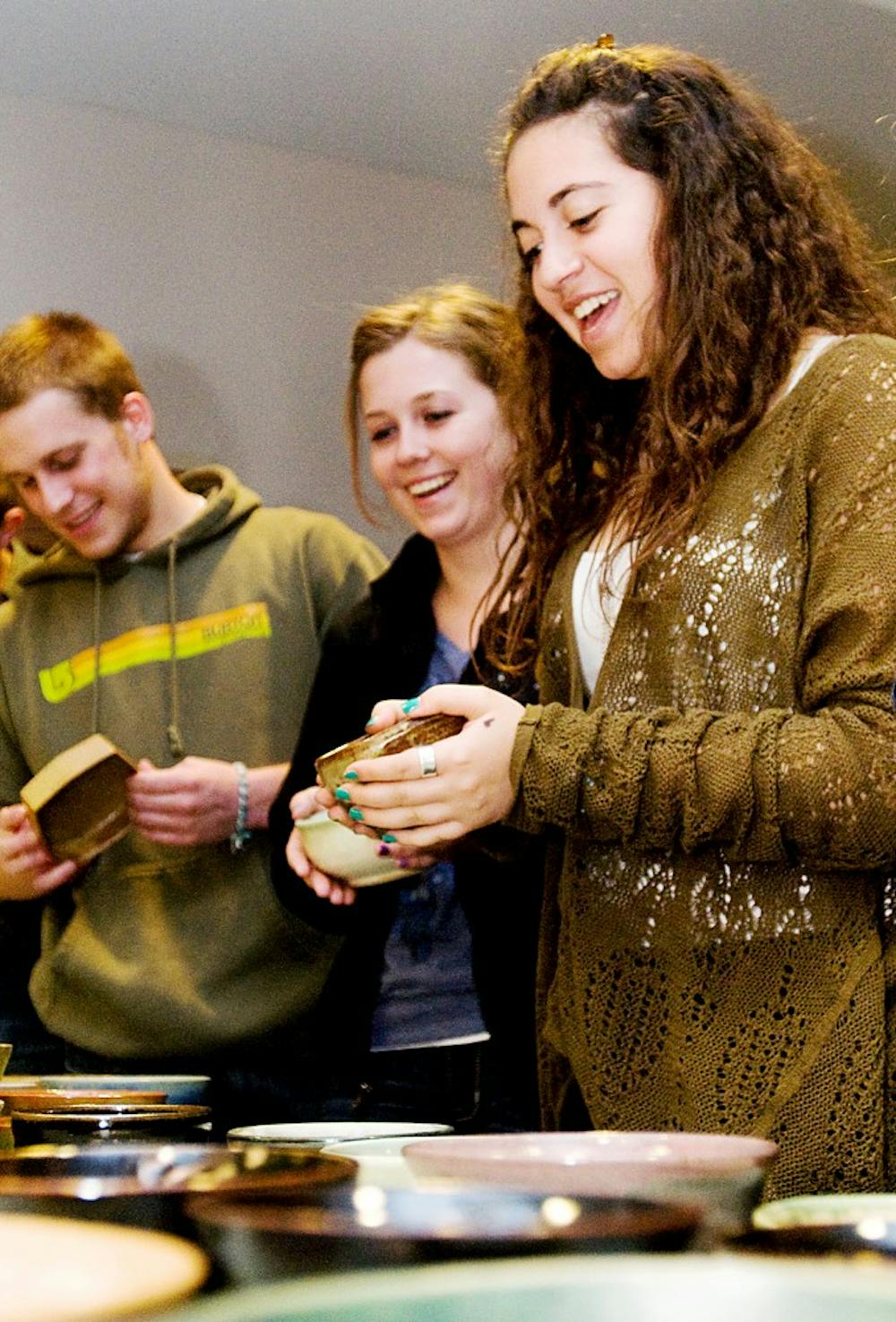 Sophomore global and area studies sophomore Mikole Leuran, right, and undecided freshman Rheanne Pecsenye contemplate which soup bowl to use for the Empty Bowls Fundraiser Wednesday at the Hannah Community Center, 819 Abbot Road. The bowls were made by students in the Clay Club, the ceramics club at MSU. Jaclyn McNeal/The State News