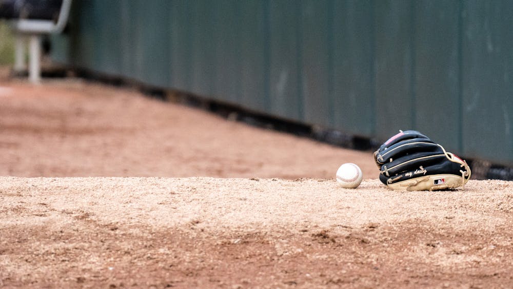 <p>A mitt and ball lay on the ground during the MSU versus Oakland matchup, April 19, 2022.</p>