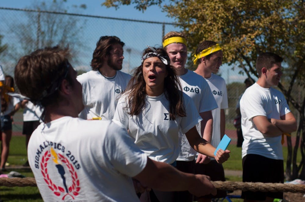 <p>Marketing sophomore Emma Prevoznak motivates advertising junior Eric Kanema during a tug-o-war during the annual Sigma Olympics, hosted by Sigma Kappa, on Sept. 27, 2015, at Patriarche Park in East Lansing.</p>