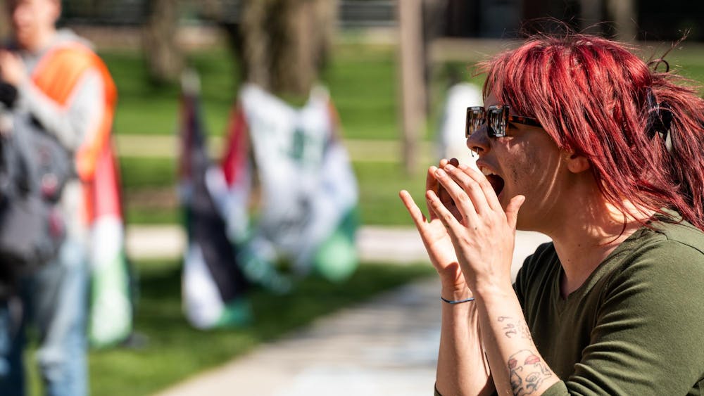 A Michigan State University community member leads a chant at the Gaza solidarity encampment in People’s Park on MSU’s campus on April 25, 2024.