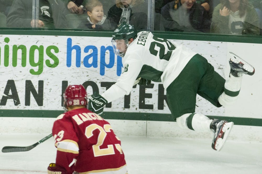 Senior forward Thomas Ebbing (28) dives for the puck during the game against Denveron Oct. 21, 2016 at Munn Ice Arena.  The Spartans were defeated by the Pioneers, 2-1. 