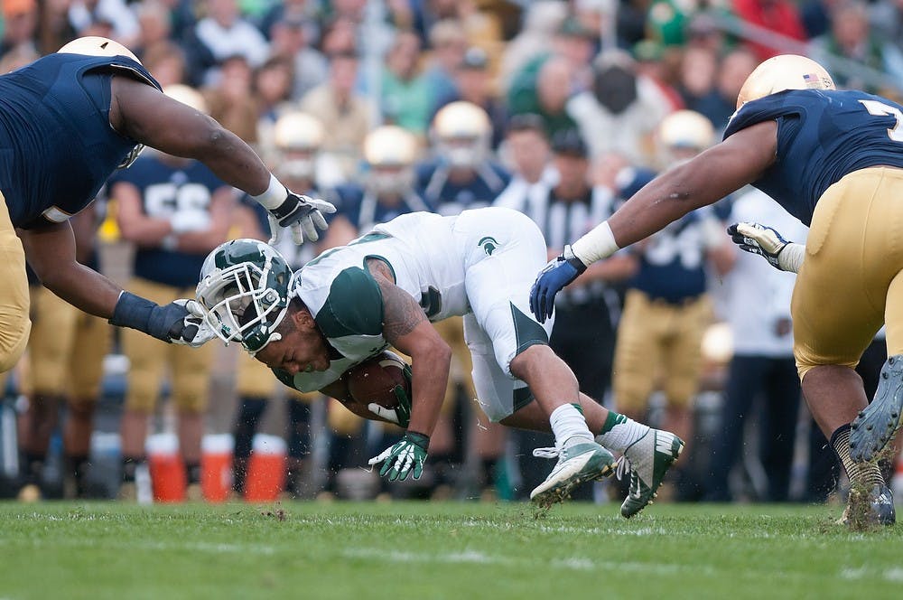 	<p>Notre Dame defensive lineman Louis Nix <span class="caps">III</span> rips off junior running back Nick Hill&#8217;s helmet during a game Sept. 21, 2013, at Notre Dame Stadium in South Bend, Ind. A flag was later called on the play. Julia Nagy/The State News</p>
