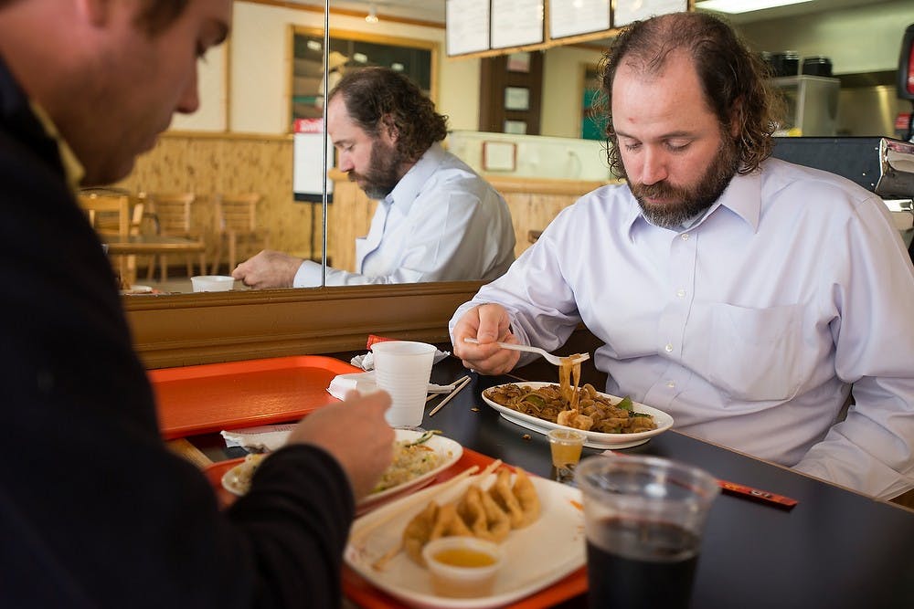 <p>Laingsburg, Mich., resident Aaron Wekenmen, right, and Williamston, Mich., resident Mike Mitchell eat lunch Sept. 18, 2014, at Thai 102 Degrees, 225 M.A.C. Ave., in East Lansing. Julia Nagy/The State News</p>