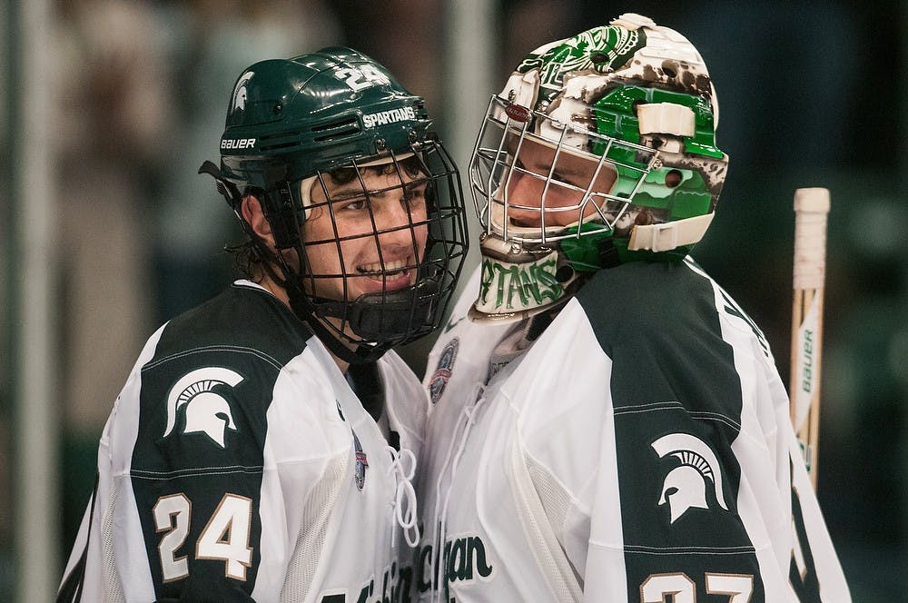 Freshman forward Justin Hoomaian, left, celebrates the Spartan's win over Michigan with junior goalie Will Yanakeff on Nov. 10, 2012, at Munn Ice Arena. The Spartans won 7-2. Julia Nagy/The State News