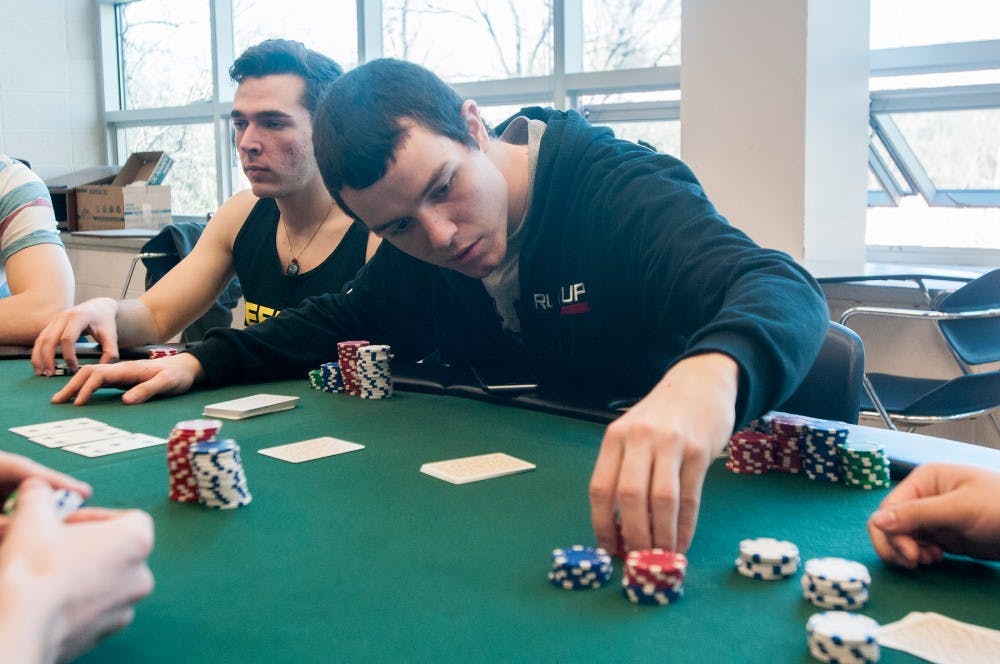 History education junior Jason Andrews counts chips during a poker club meeting on Feb. 19, 2015 in Erickson Hall. Members of the club meet weekly and play poker against one another, competing for points. 