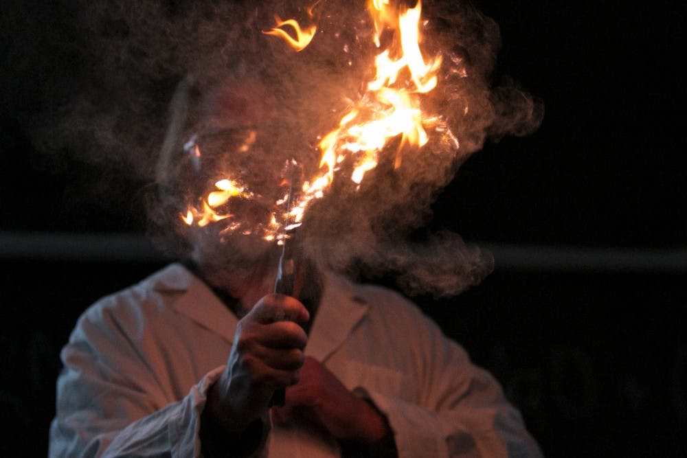 Chemistry professor James H. Geiger holds a flame while wheat dust is thrown into the fire during Keep Calm: It's Only An Explosion which is a chemistry demonstration going on as a part of the MSU Science Festival on April 14, 2016 in the Chemistry Building.  Geiger says he likes demonstrating chemistry because he wants to spark interest for both adults and children to learn more about chemistry. 