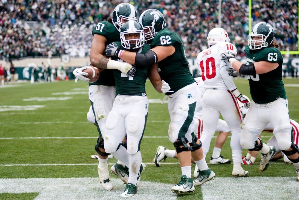 Junior running back Edwin Baker celebrates his touchdown with teammates junior offensive tackle Fou Fonoti, left, and junior offensive guard Chris McDonald, right, during Saturday's game against Indiana in Spartan Stadium. The Spartans defeated the Hoosiers, 55-3. Lauren Wood/The State News