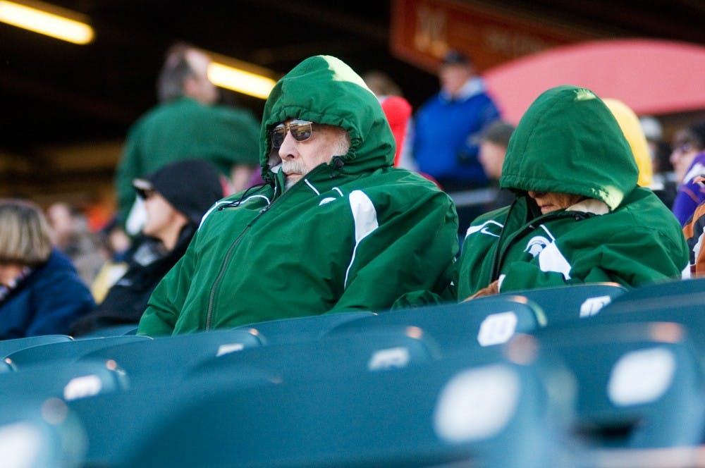 Hanover, Mich., residents Ken and Dianne McGuire sit bundled and trying to keep warm during the Crosstown Showdown on Tuesday at Cooley Law School Stadium. "I've been rooting for State since about 1948," Ken McGuire said. Kat Petersen/The State News